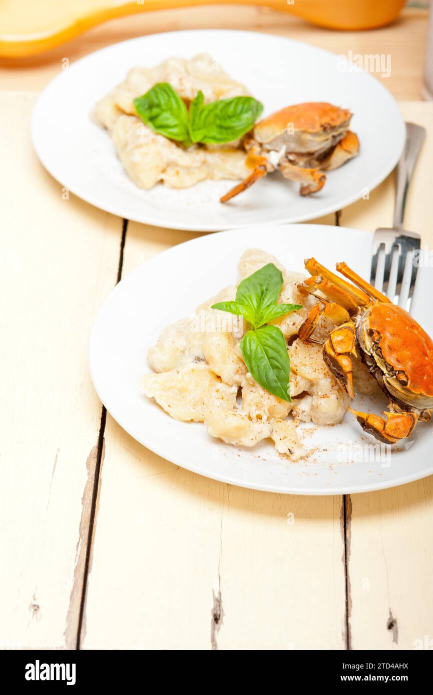 Fresh homemade Italian gnocchi with seafood sauce crab and basil Stock Photo