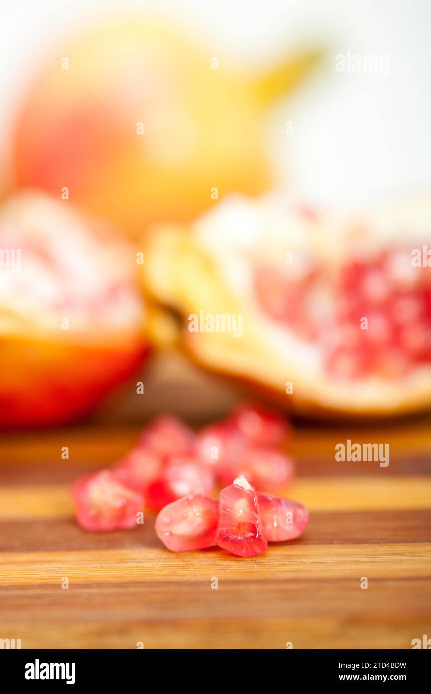 Fresh pomegranate fruit over wood cutting board, food photography Stock Photo