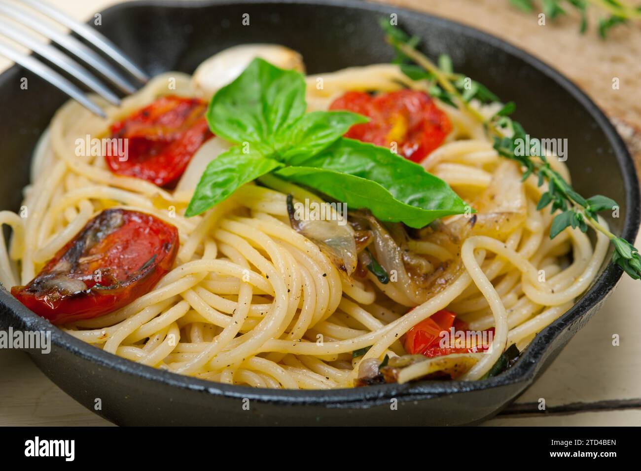 Italian spaghetti pasta with baked tomatoes basil and thyme sauce on a