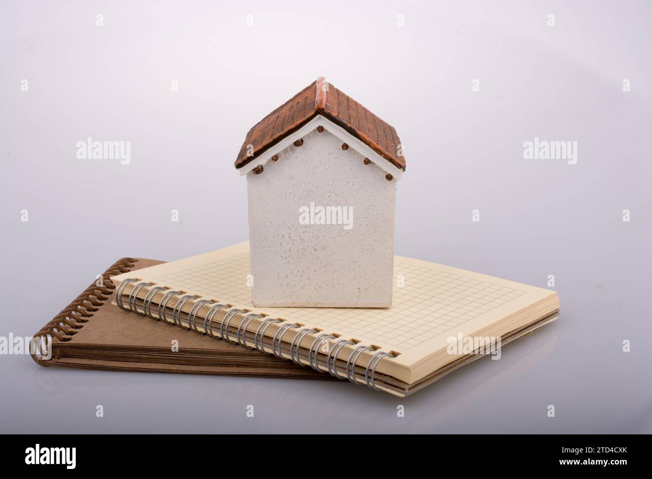 Little model house placed on an a brown color notebook Stock Photo