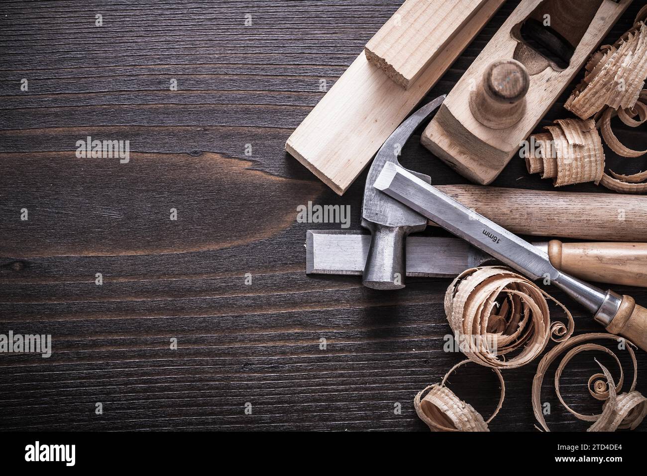 Planner claw hammer fixed chisel wooden bricks and curled shavings on vintage wooden board Building concept Stock Photo