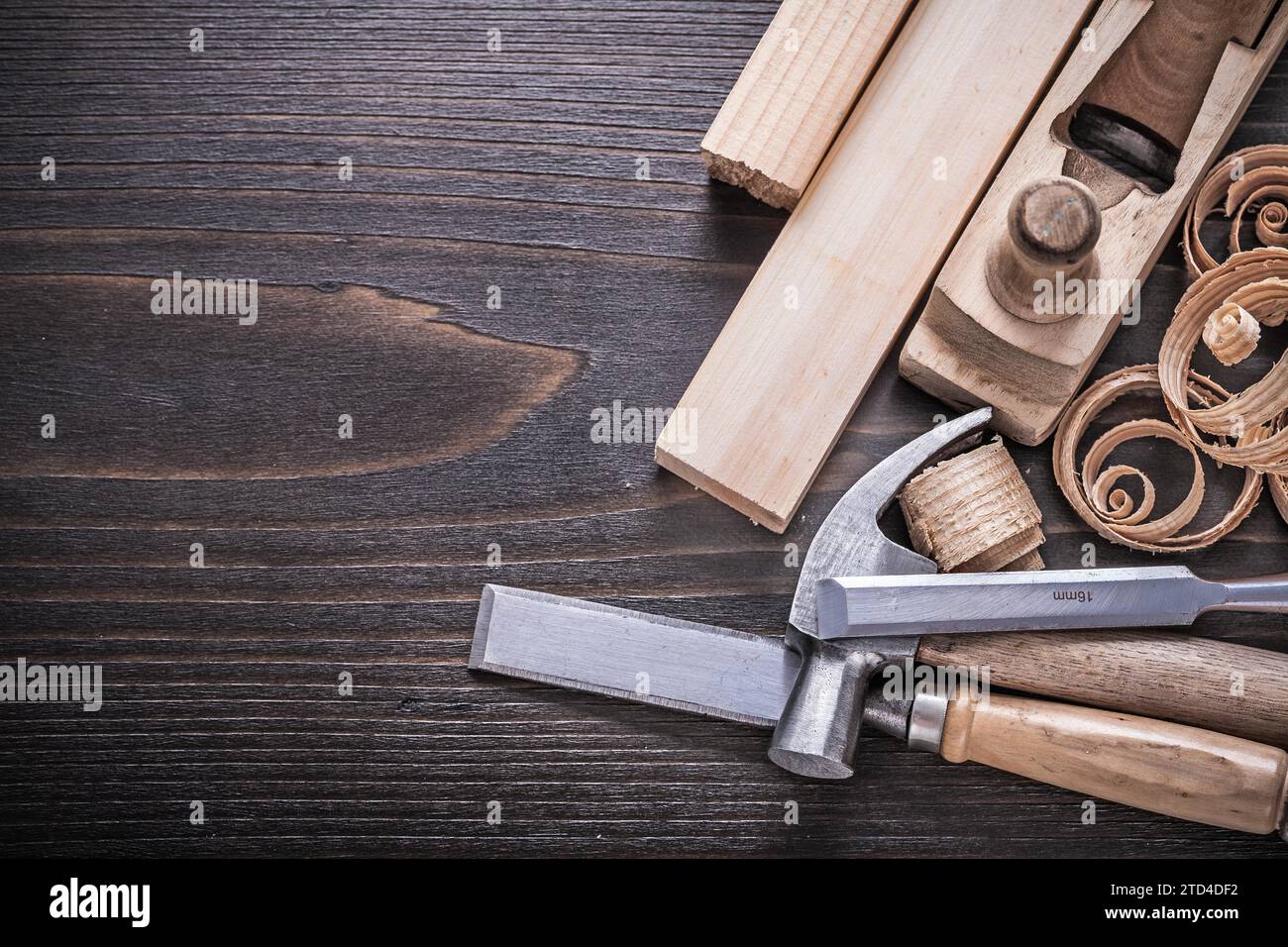 Planner claw hammer metal chisel wooden bolt and curled shavings on vintage wooden board building concept Stock Photo