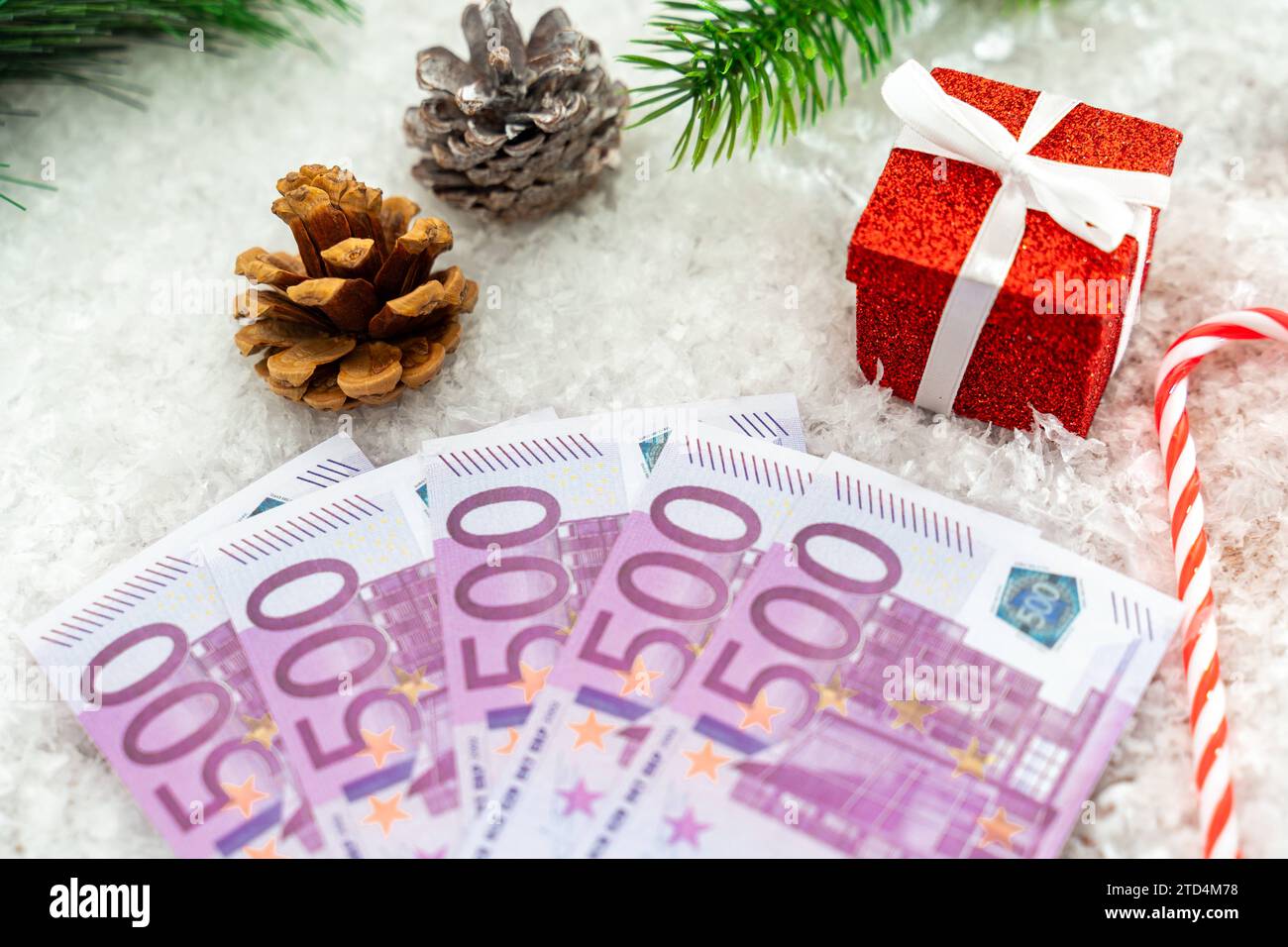 December 15, 2023: Money for Christmas concept, euro cash bills in snow between winter decorations and presents *** Geld zu Weihnachten Konzept, Euro Bargeld Scheine in Schnee zwischen winterlicher Dekoration und Geschenken Stock Photo