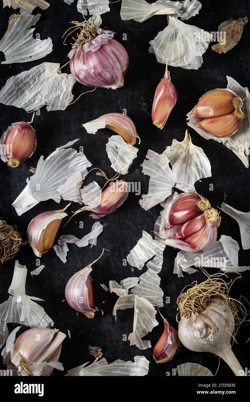 Fresh garlic bulbs and cloves grouped on black background. Flat lay ...