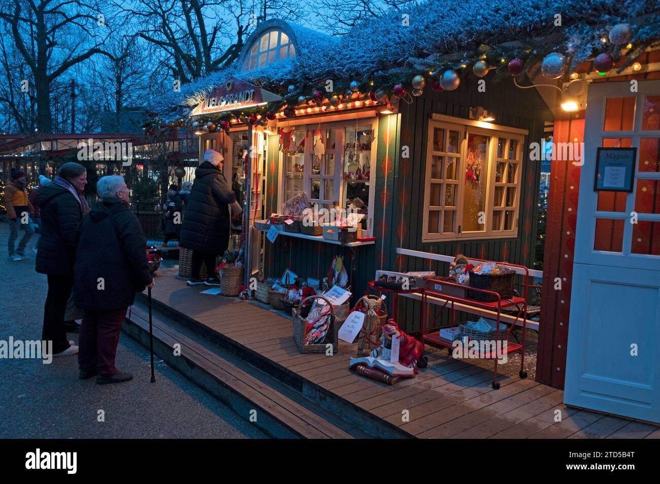 Crowds meander around the small shops in Tivoli Gardens, Christmas shopping and enjoying the festival lights as part of the Julemarked (Christmas mark Stock Photo