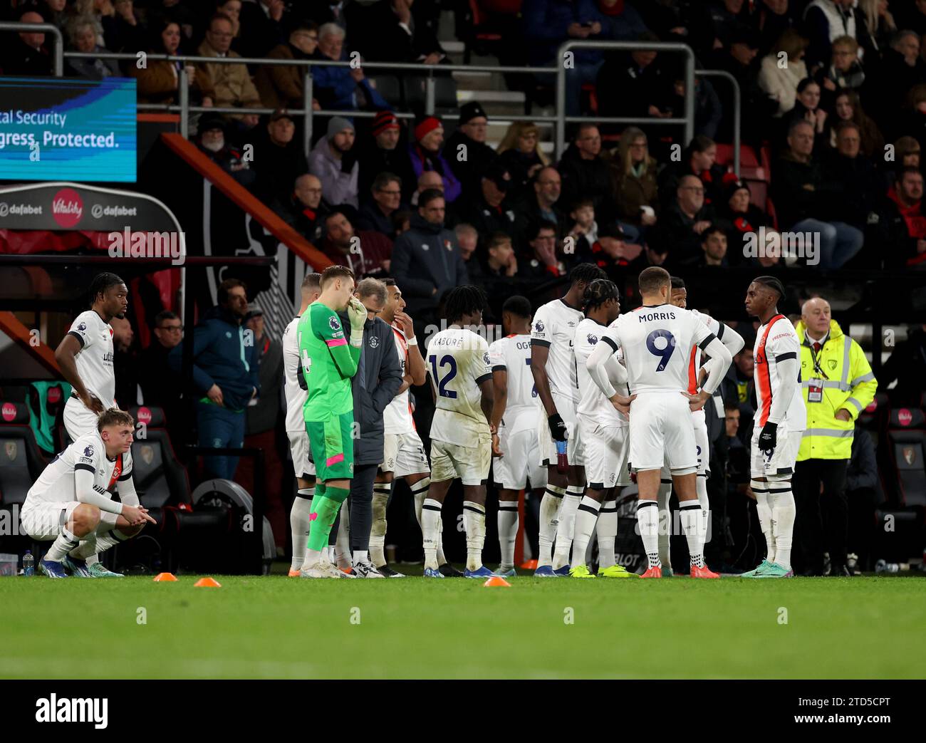 Luton Town's players wait on the side line as their team mate Tom Lockyer receives treatment on the pitch during the Premier League match at the Vitality Stadium, Bournemouth. Picture date: Saturday December 16, 2023. Stock Photo