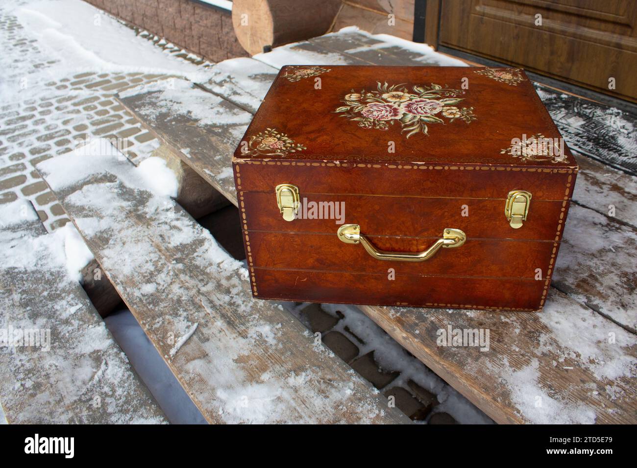 Old wooden antique box on wooden open porch. Wooden antique patterned