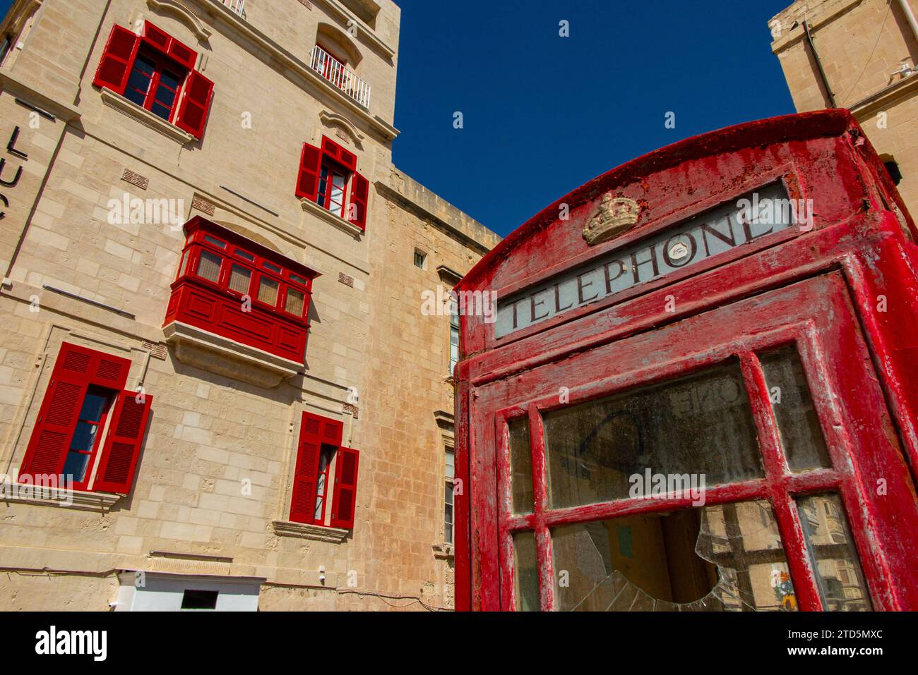 A red British telephone box outside the Bridge bar building, Liesse with a red British telephone box in the foreground, Valletta, Malta. Stock Photo