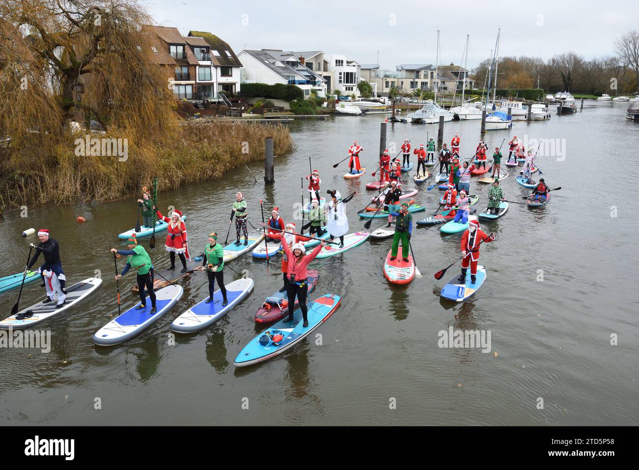 Group of paddle boarders dressed as Santa and Elves. Christmas event arranged by the BH Activity Junkies on the river Stour in Christchurch Dorset UK Stock Photo