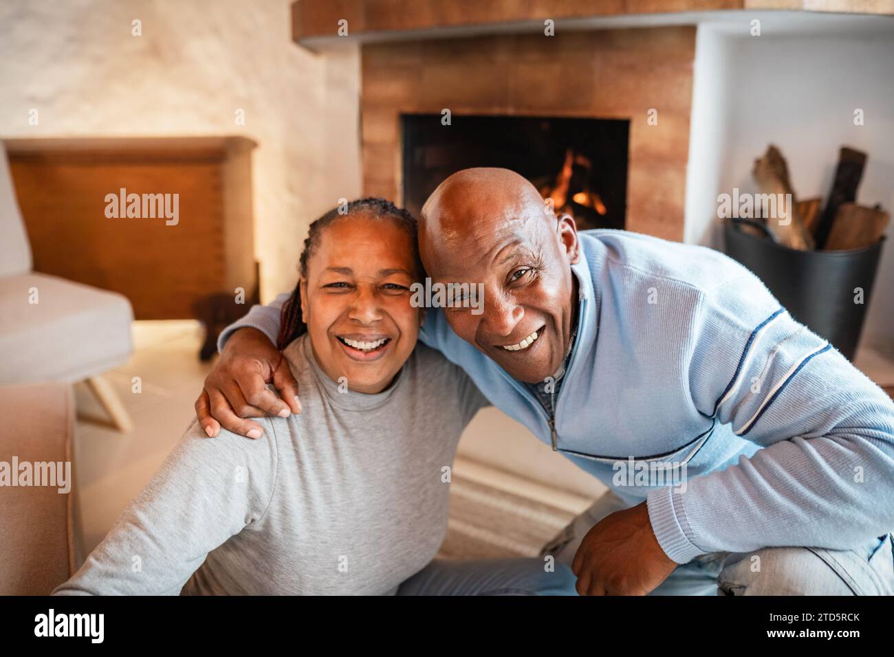 Happy African senior couple smiling into the camera in warmth cozy house Stock Photo