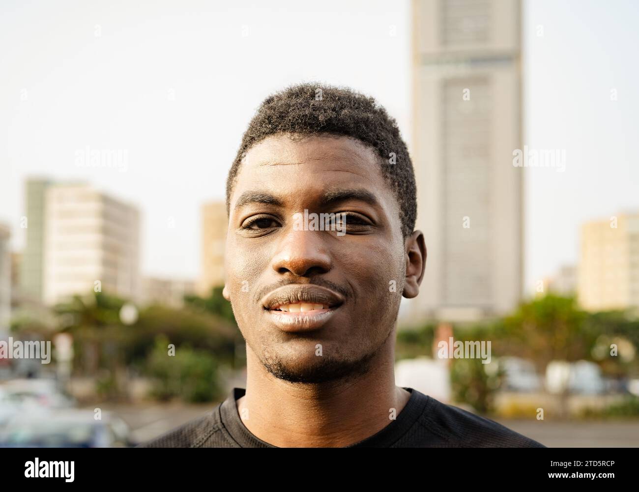 Happy young African teenager looking in front of camera in the city Stock Photo