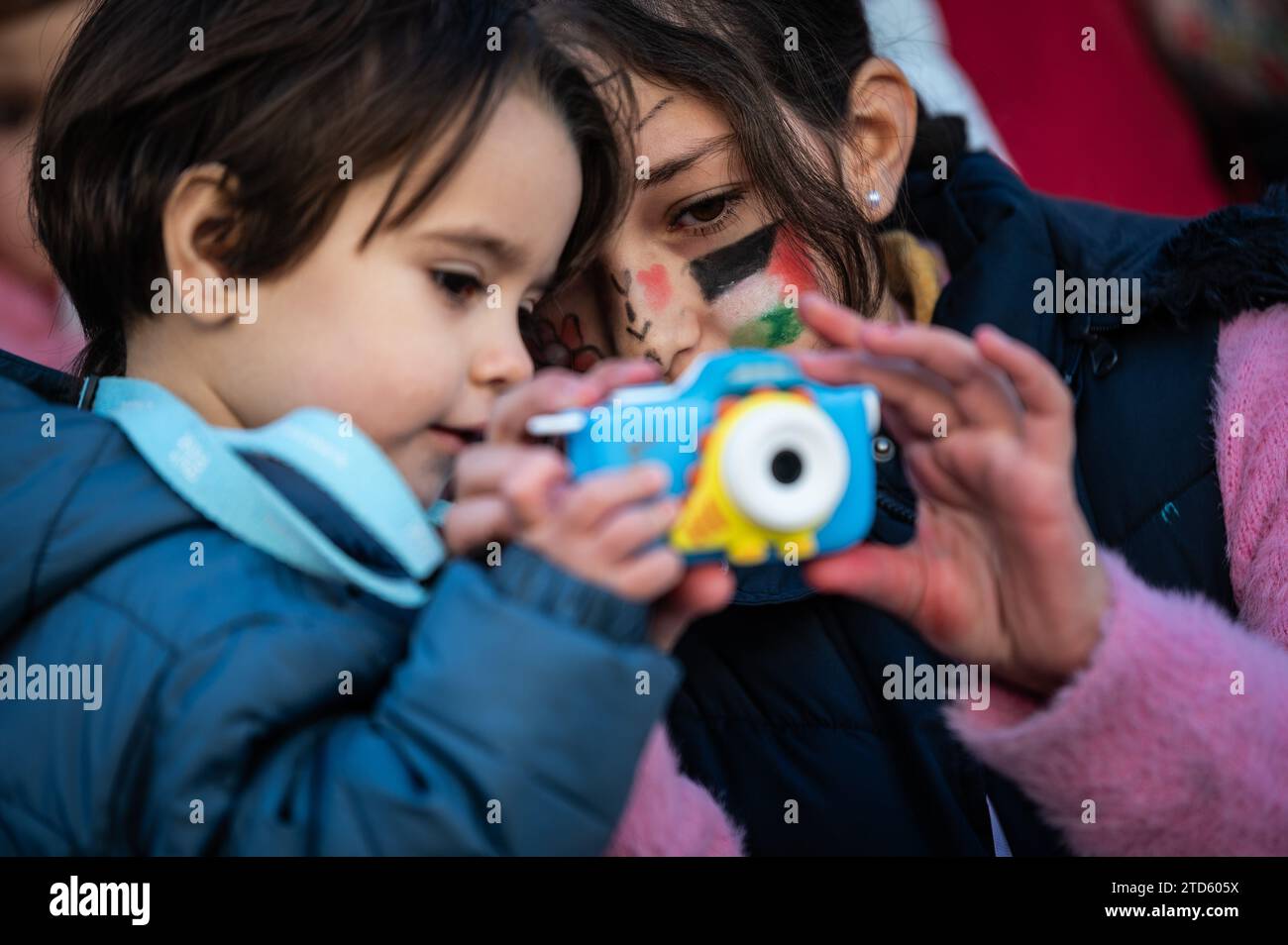 Madrid, Spain. 16th Dec, 2023. Children take pictures during a protest in solidarity with Palestinian children. Children and their parents have gathered to give support to the children from Gaza, Palestine, during a demonstration in front of the Congress of Deputies. Over 18,000 Palestinians have been killed in the Gaza Strip since October 7, 2023, as a result of Israeli airstrikes during the conflict between Israel and Palestine. Credit: Marcos del Mazo/Alamy Live News Stock Photo