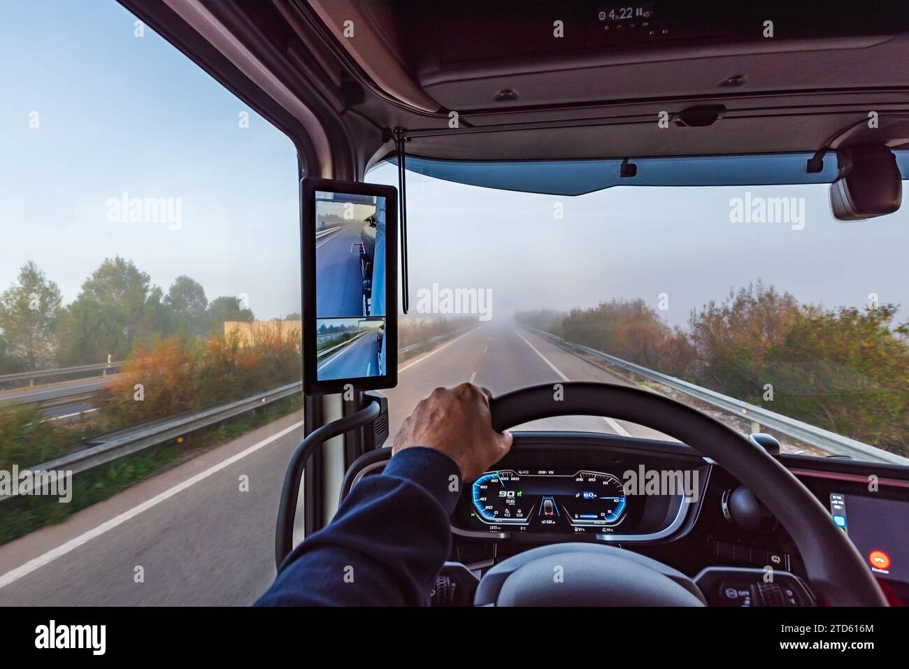 View from the inside of the cabin of a truck on a highway with fog. Stock Photo