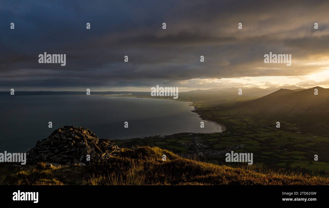 Sunrising through the mountains onto the Welsh coastline Stock Photo