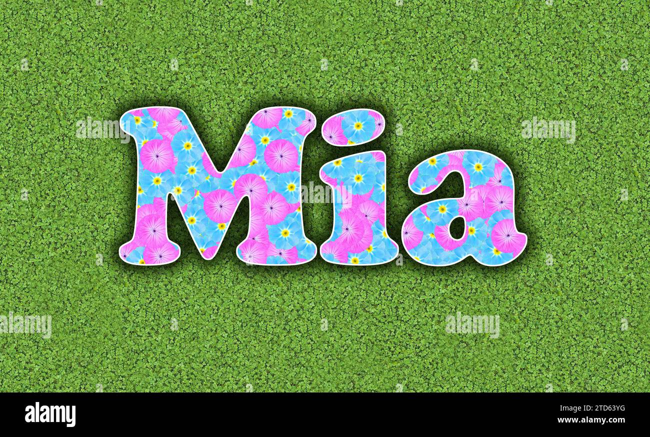 Mia, one of the ten most popular girls' first names in the USA, 2023, written with flowers in baby colours, pink and light blue, on a green background Stock Photo