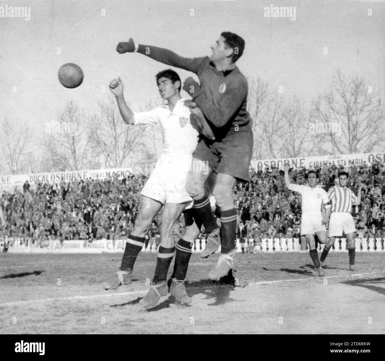 Real's goalkeeper punches the ball harassed by Herrera add documentation photo Id 8531198. - Sevilla-real Sociedad match valid for the first division league of the 1943-44 season, played at the Nervión field on February 20, 1944 , with Sevillista victory 4-0 with goals from Herrera, Rincón, Iturbe and Campos. In the Image, Real's goalkeeper, Galarraga, Clears His Fists in the face of harassment from Herrera, scorer of the first Sevilla goal. (photo Serrano). Credit: Album / Archivo ABC / Serrano Stock Photo