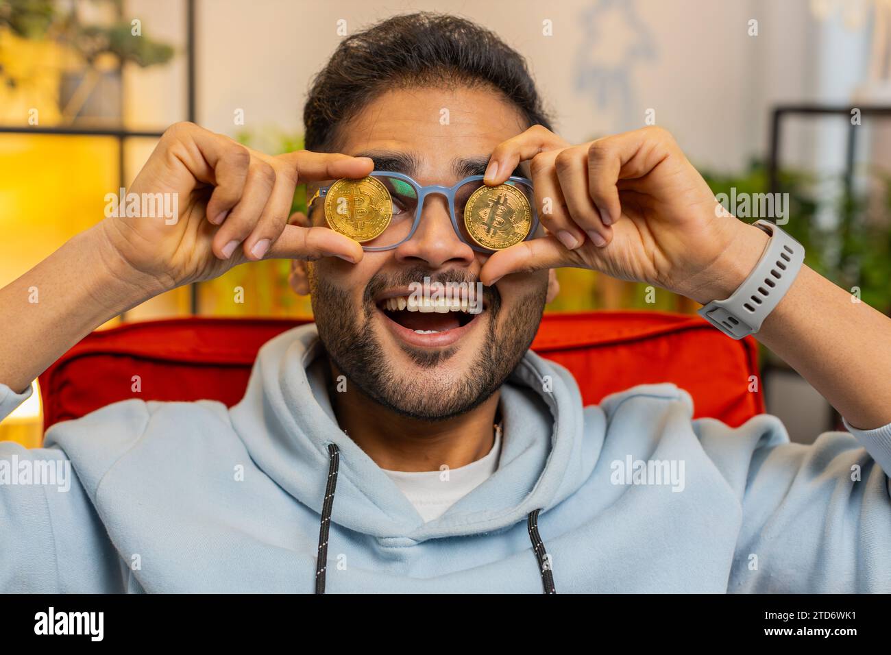 Indian man freelancer holding gold coin successful developer programmer.  Ok. Hindu guy stock trader earning bitcoins after online monitoring trading  operations. Increasing wealth financial prosperity Stock Photo - Alamy