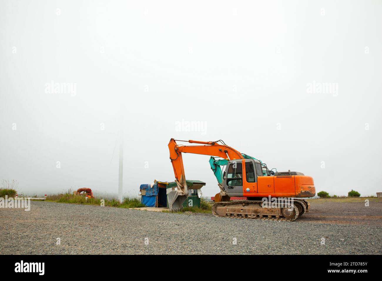a orange parked big excavator, construction car, earthmoving heavy equipment on cloudy day Stock