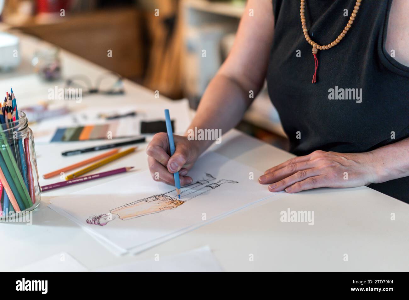 High angle of a fashion designer drawing a fashion sketch with colorful ...