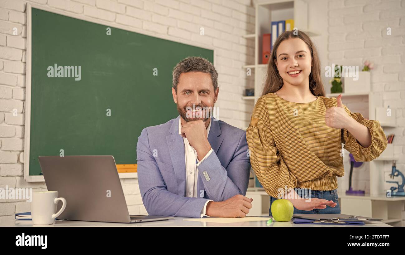 cheerful teen child with man teacher in classroom. education Stock ...