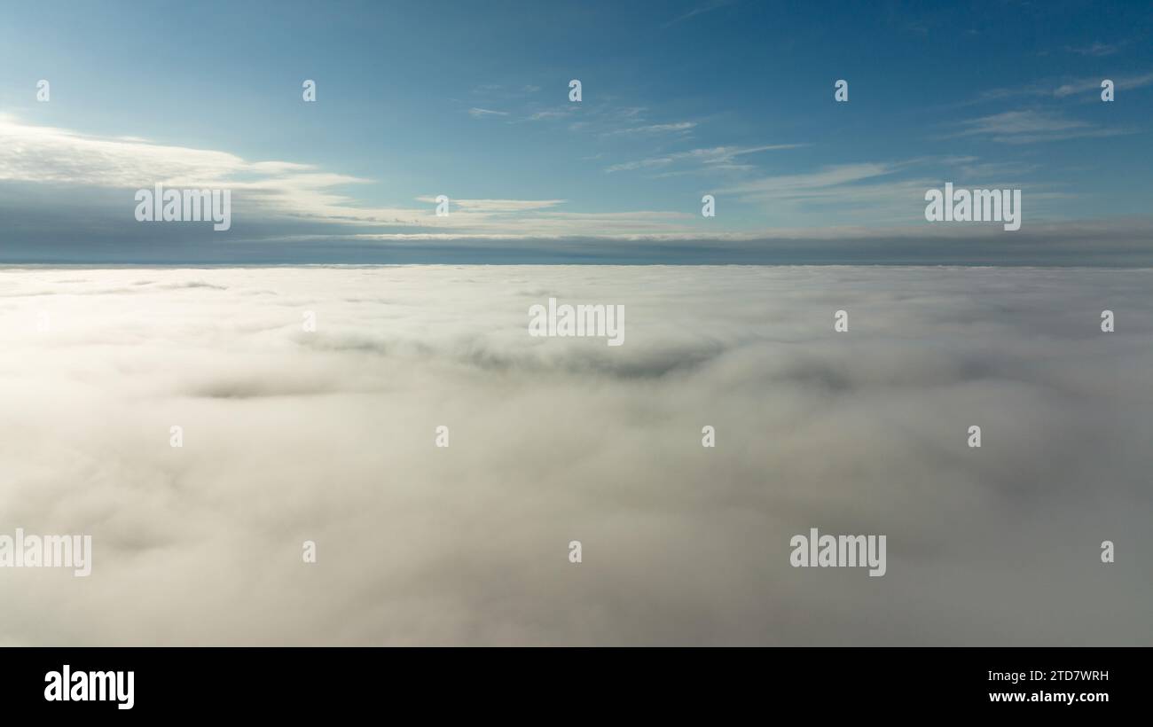 CFlying high above the clouds. Aerial view of clouds and horizon from drone. Thunderclouds from above before rain. Tragic gloomy natural landscape of Stock Photo