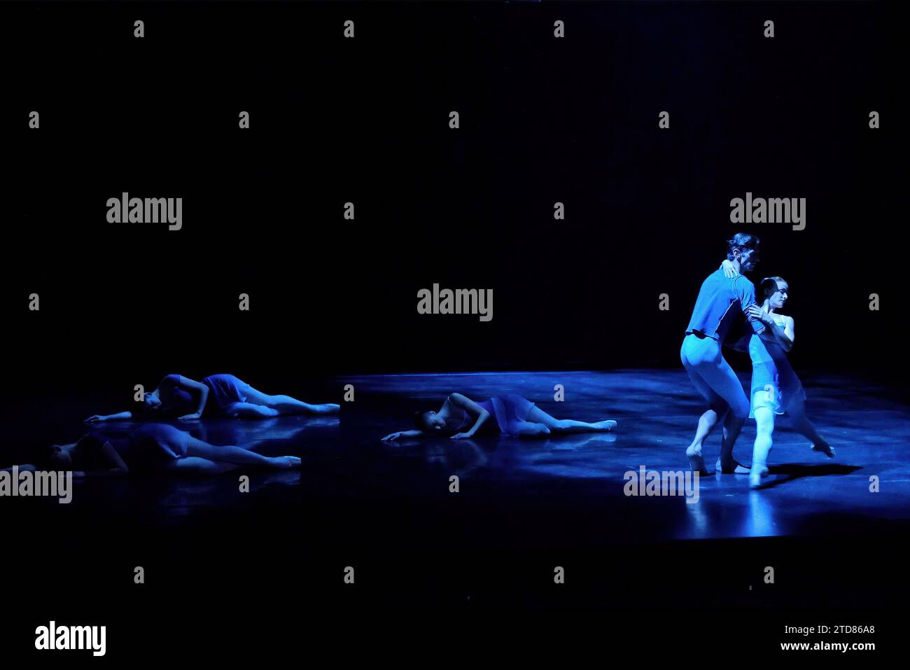 Three dancers lie on stage, two dance in a blue spotlight - The Australian Ballet  ART TO SKY (preview 2014)  Choreography Stephen Baynes Stock Photo
