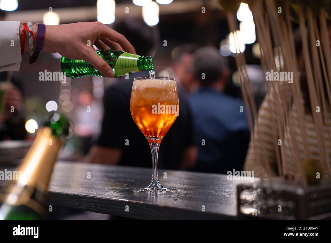 Professional bartender pours a drink in to glass on a festive