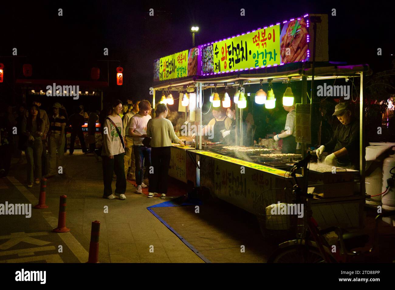 Seoul, South Korea - June 3, 2023: Under twinkling lightbulbs, a food cart in Yeouido Hangang Park comes alive at night, serving delicious street food Stock Photo