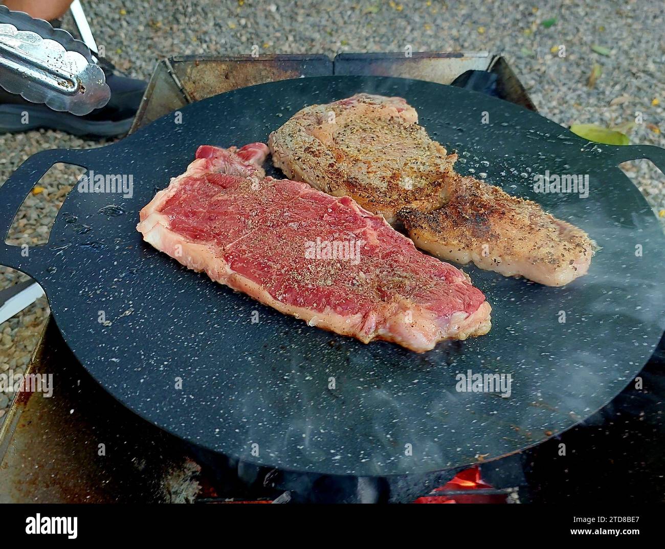 Cooking steaks at camping. Fry steaks in a frying pan at camping