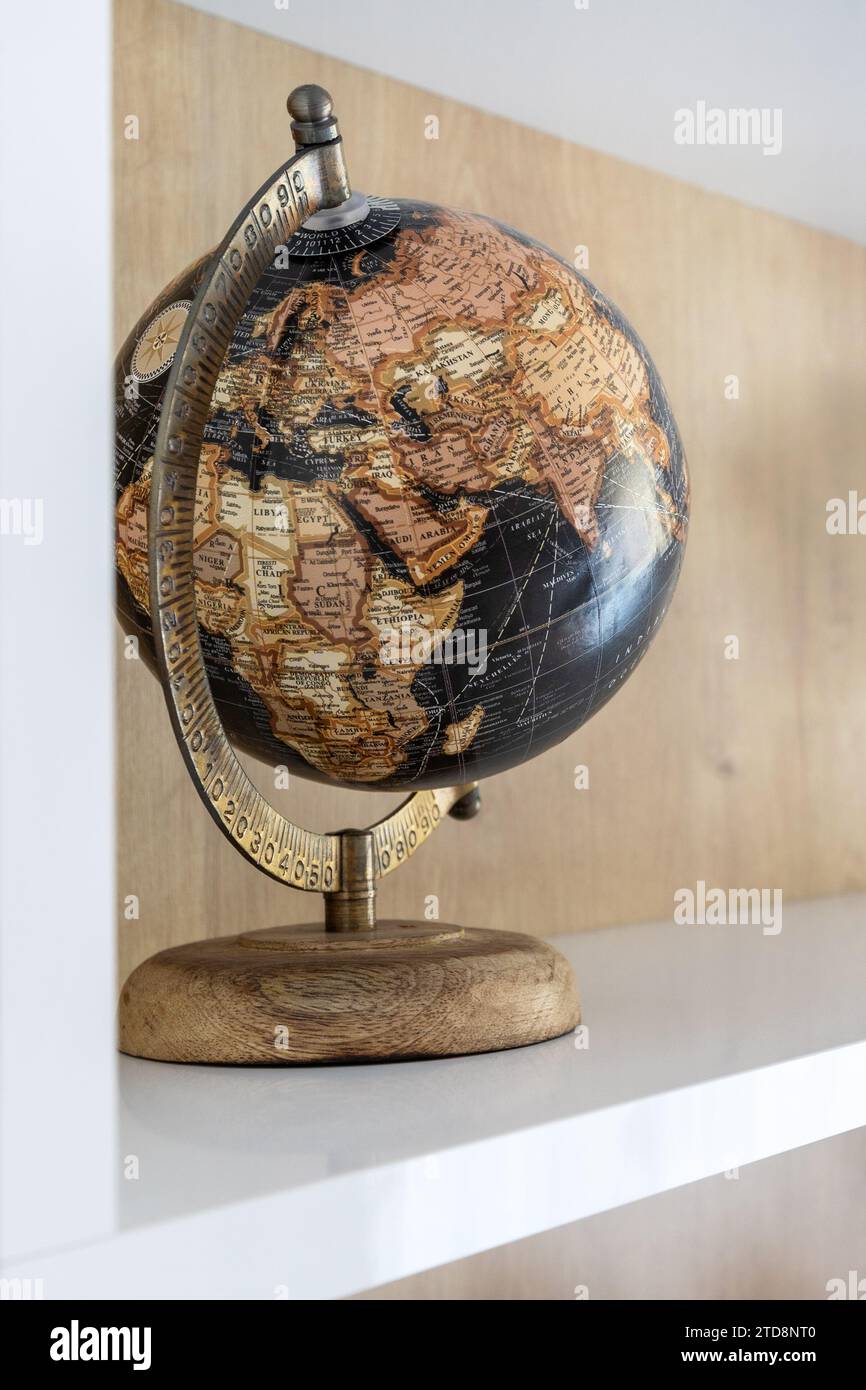 Dark geographical globe in cabinet on the shelf. Science, education, travel background Stock Photo