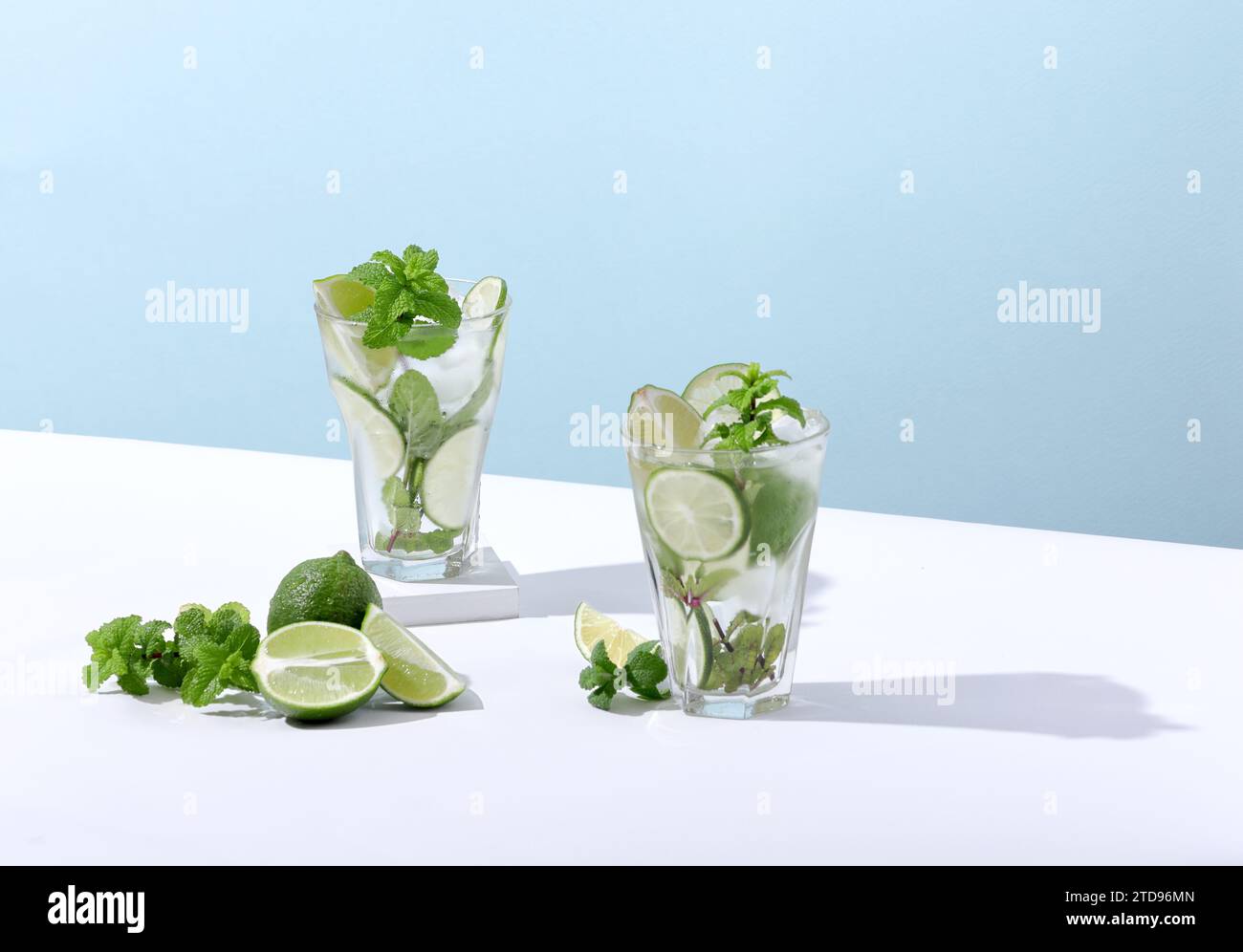 Ice and mojito in a glass lie on the table with a strong shadow Stock Photo