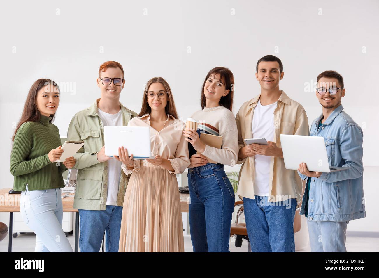 Team of young programmers with gadgets in office Stock Photo