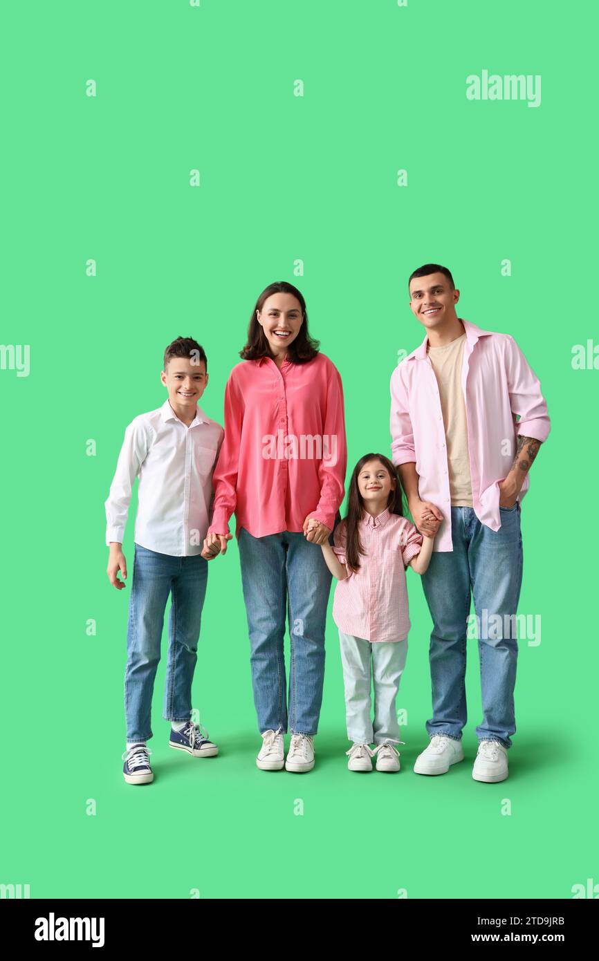 Little children with their parents holding hands on green background Stock Photo