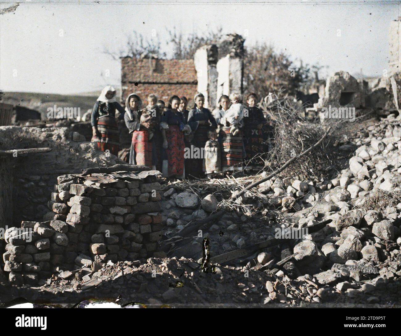 Mandjovo', surroundings of Melnik, Bulgaria Group of women and children among the rubble of the war-ravaged village, Human beings, Political life, Clothing, HD, Woman, Foreign war, Costume, Balkan Wars, exists in high definition, Group portrait, Mandjovo, Bulgarian Village Ruins, Mandjovo [environs de Melnik], 20/09/1913 - 20/09/1913, Passet, Stéphane, photographer, 1913 - Balkans, Greece, Bulgarie - Stéphane Passet - (30 August-21 October), Autochrome, photo, Glass, Autochrome, photo, Positive, Horizontal, Size 9 x 12 cm Stock Photo