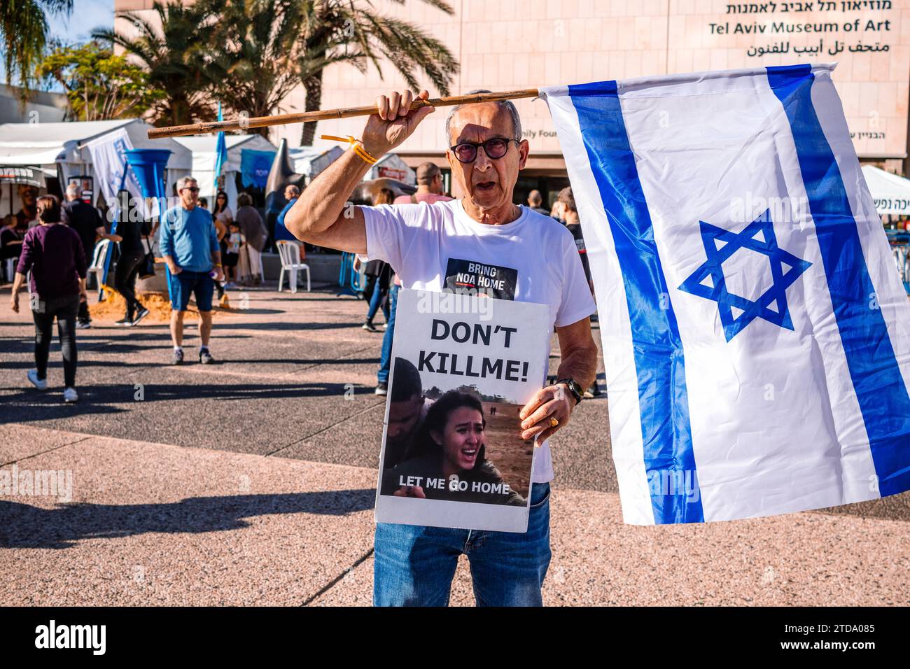 Tel Aviv, Israel - December 16, 2023 People hold up photos of hostages and march in front of the Tel Aviv Museum of Art, in what is now known as Hosta Stock Photo