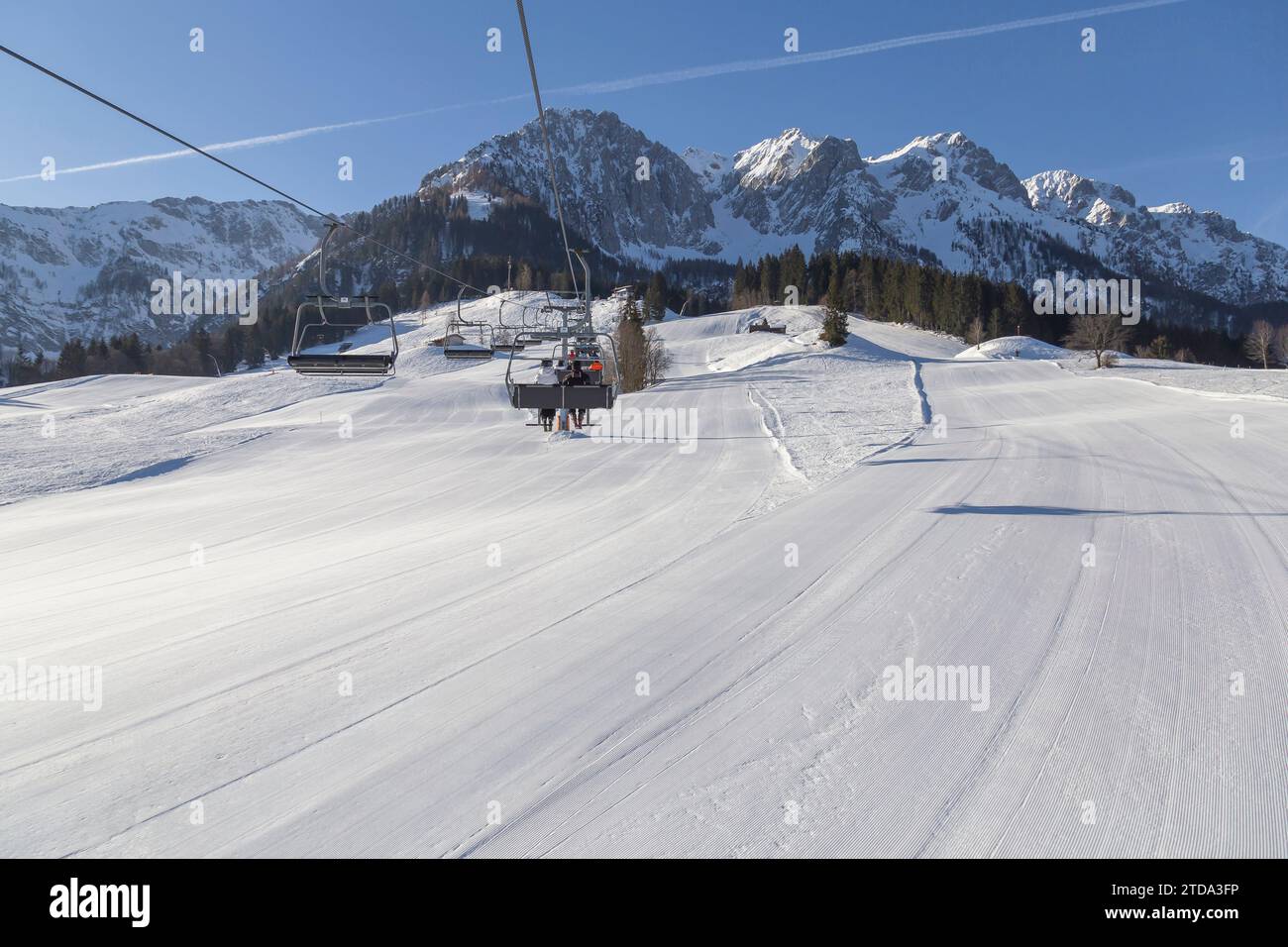 Chairlift and well-prepared ski run at a ski resort in the snowy mountains. Austria Stock Photo