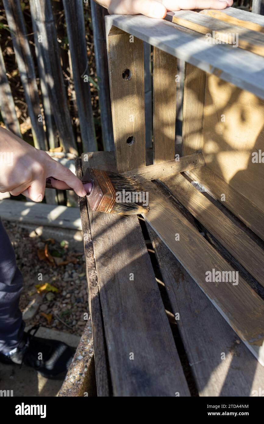 a child paints a wooden box with brushes in the garden Stock Photo