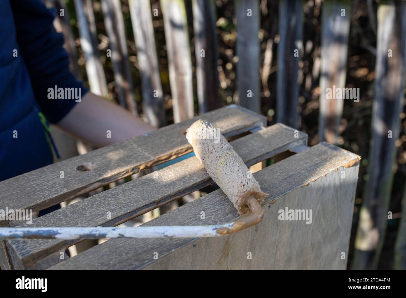 a child paints a wooden box with brushes in the garden Stock Photo