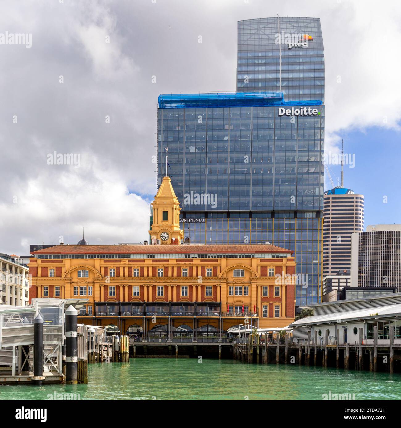 Contrast in architectural styles of the 1912 Ferry Building and the modern skyscraper office buildings of Deloitte and PWC in the downtown Auckland, N Stock Photo
