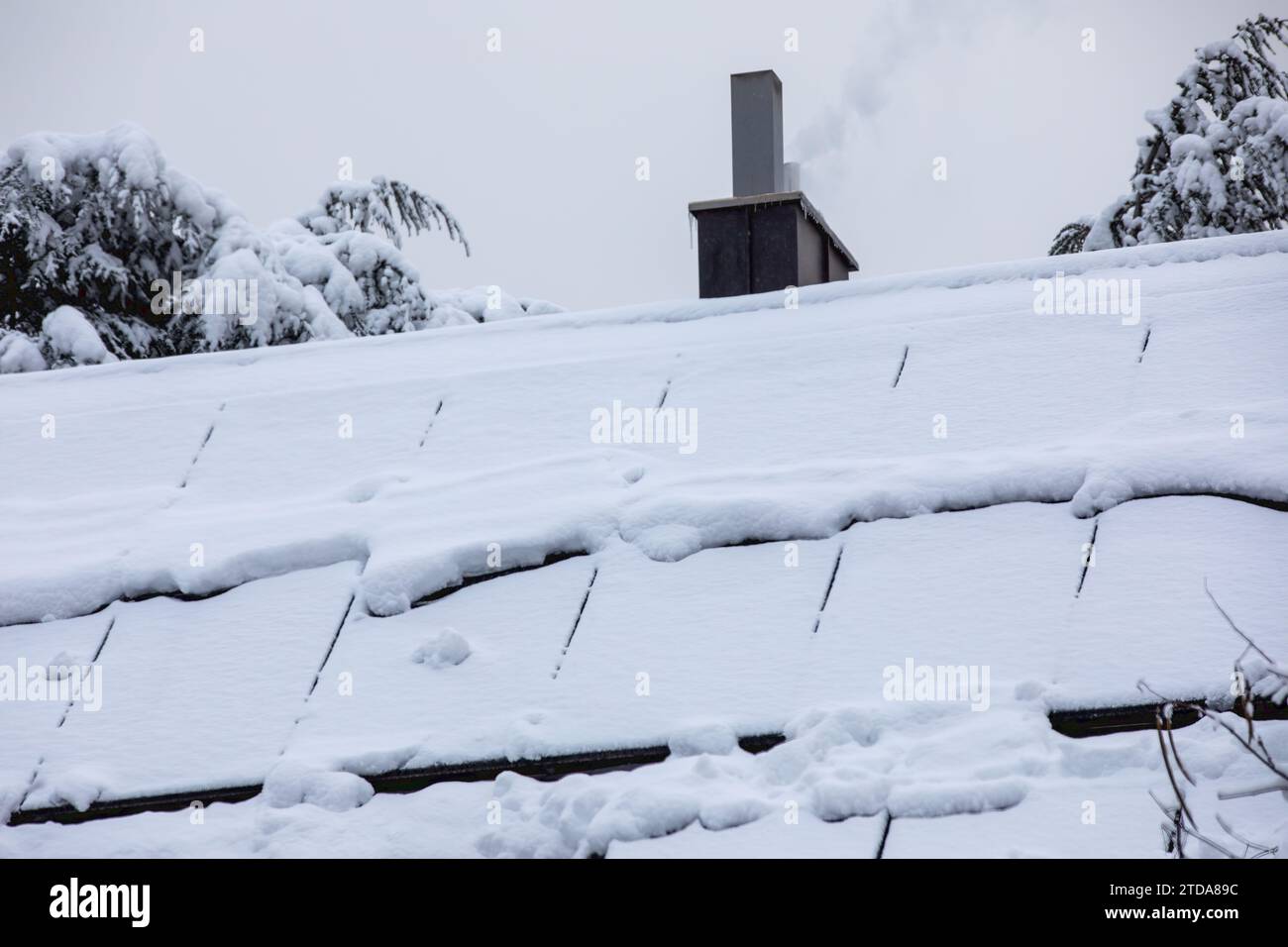 Snow-Covered Solar Panels on the Roof: Winter-Proof Renewable Energy Stock Photo