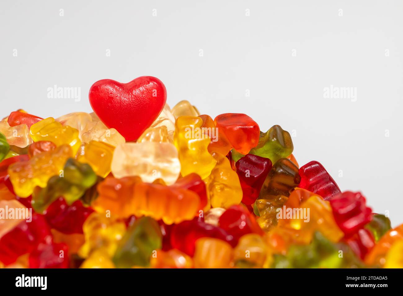 Red Heart on Delicious Pile of Colorful Gummy Bears Candy on White Background Stock Photo