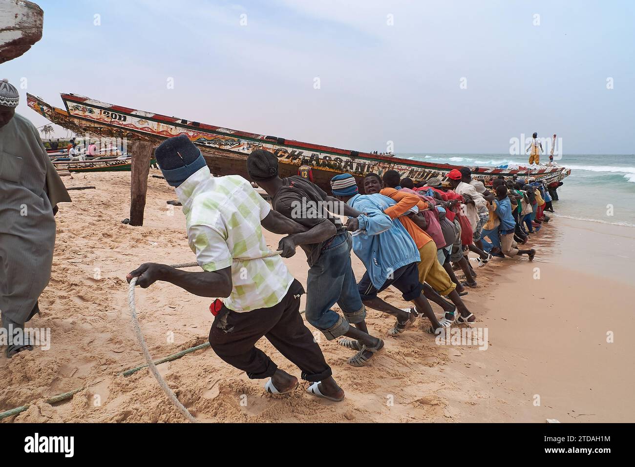 Senegalese men pulling a fishing boat onto the Ouakam beach, district of Dakar, Senegal, Africa Stock Photo