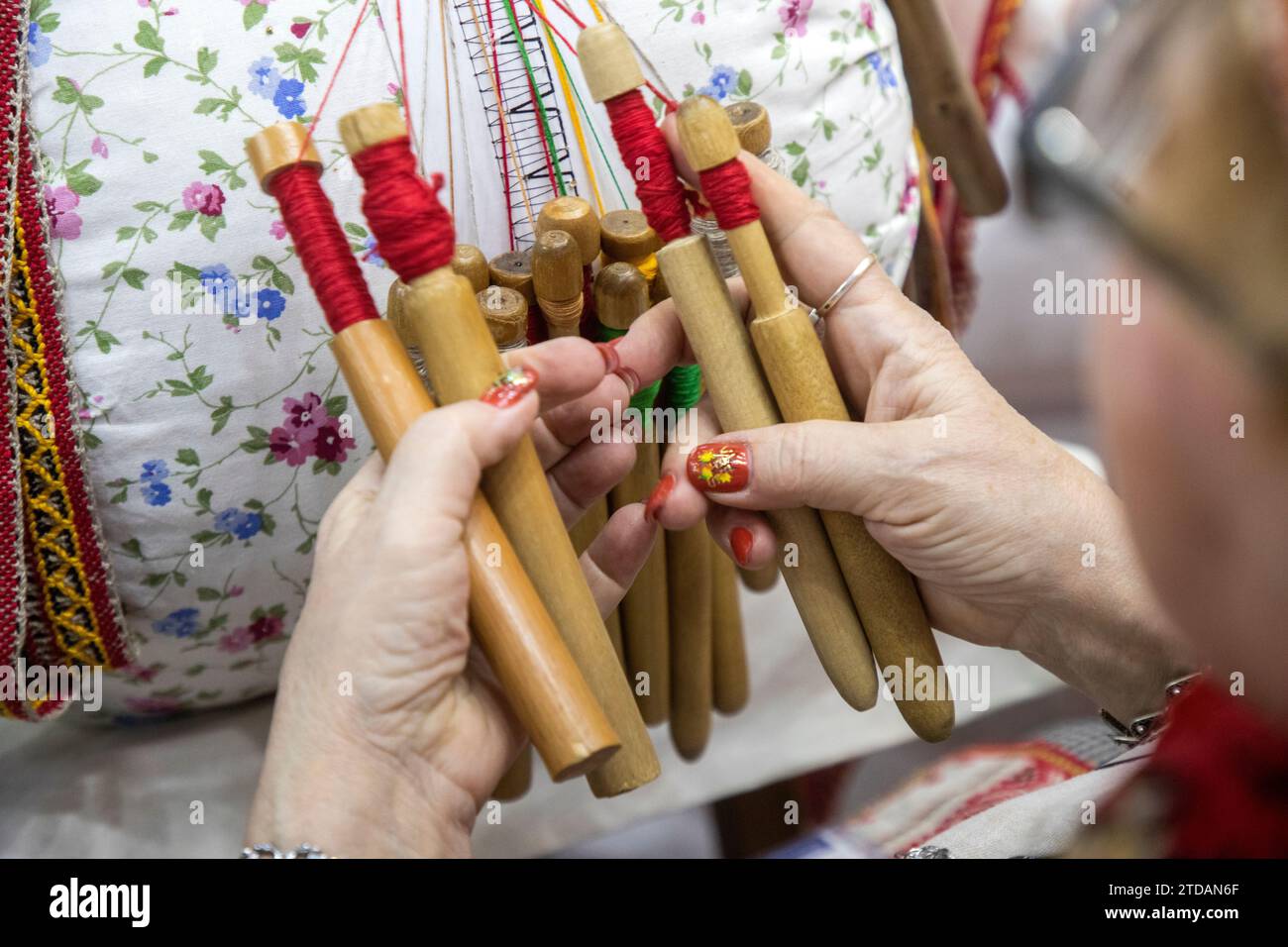 Craftswoman weaves traditional Mikhailovsky lace with a help of bobbins Stock Photo
