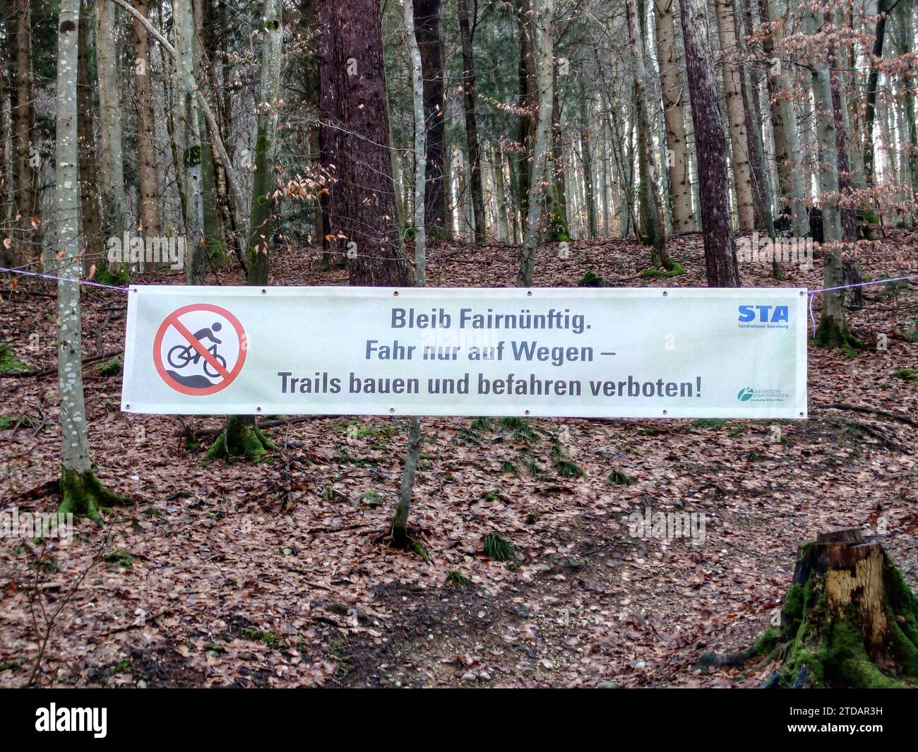 Gauting, Bavaria, Germany. 17th Dec, 2023. Banners hanging at the Gauting mountain bike trails near Munich, Germany. The county of Starnberg recently closed the trails, some of which have been there for two decades, hanging signs confirming the ban, and informing people by the newspapers that police will be patrolling the trails and issuing tickets. Critics reiterate that the trails have been there for decades in some cases and the rules being applied by Bavaria that state all trails must be accessible to foot traffic are archaic and incorrectly applied here. Critics also point out that som Stock Photo