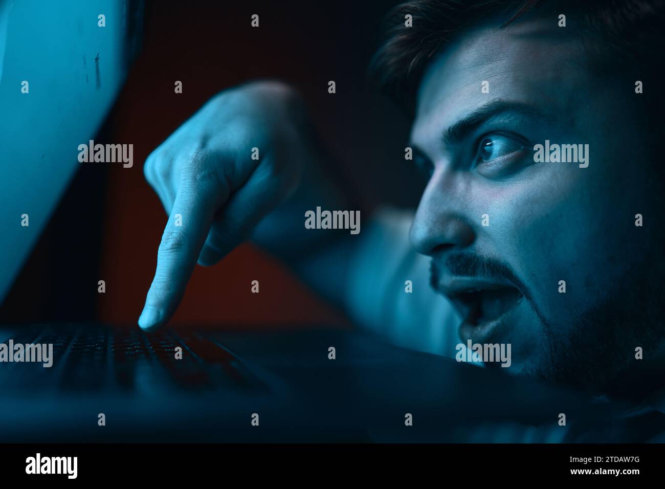 A man with a crazy, gambling expression on his face presses enter. Stock Photo