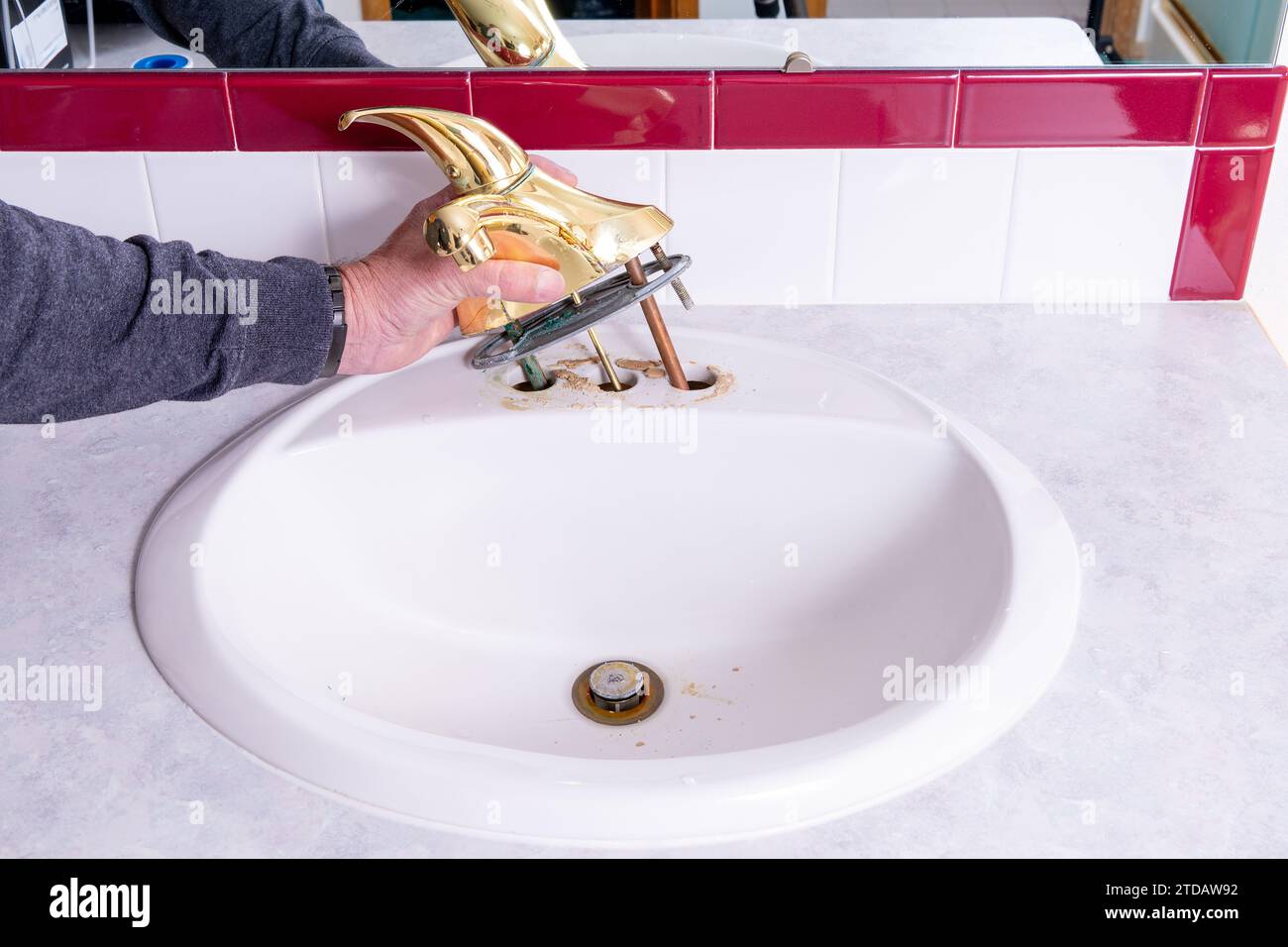 Gold colored sink faucet pulled from sink Stock Photo