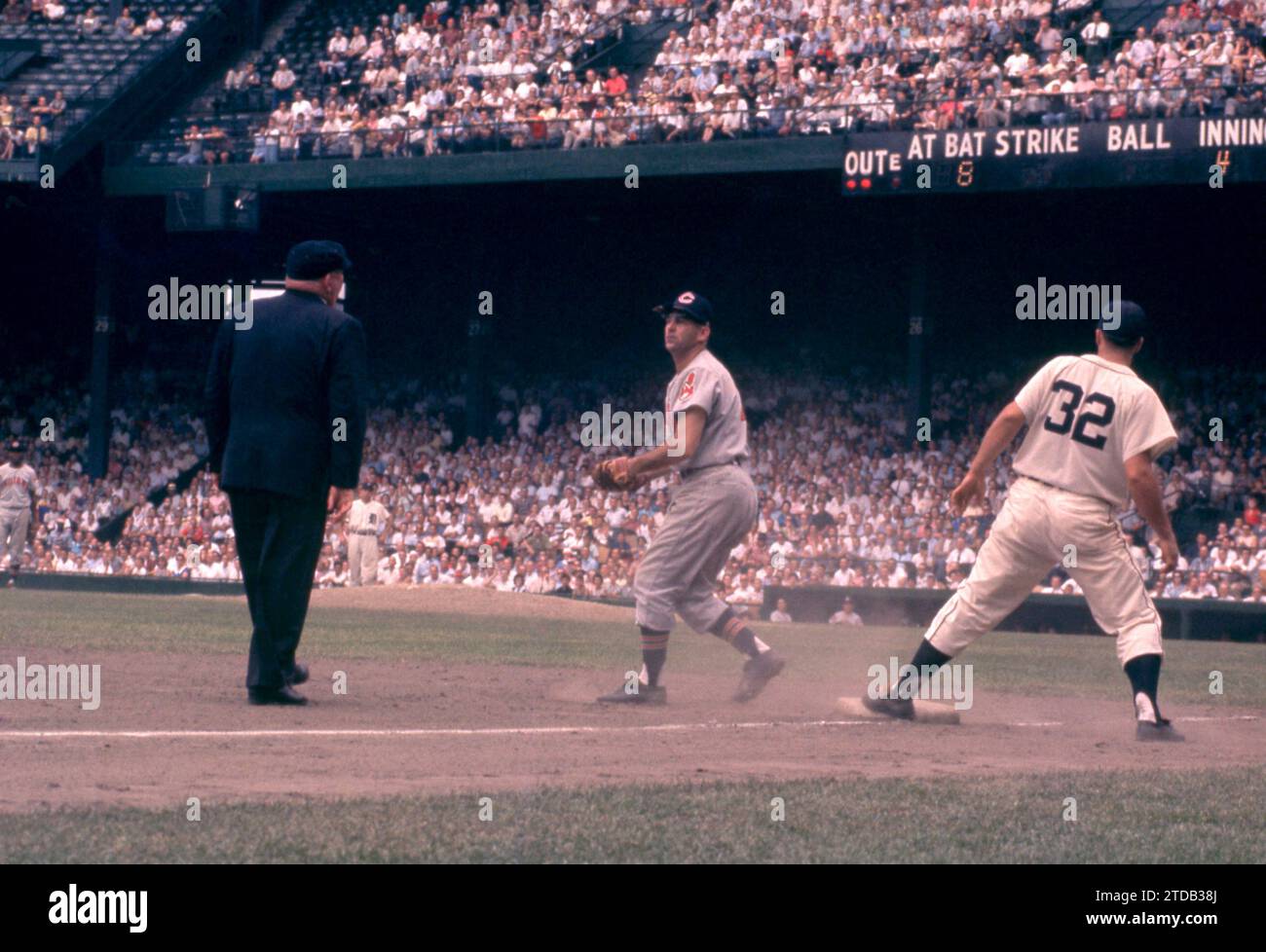 DETROIT, MI - JULY 5: Third baseman Granny Hamner #7 of the Cleveland Indians misses the tag as Bobo Osborne #32 of the Detroit Tigers reaches third base as umpire Bill Summers is there to make the call during an MLB game on July 5, 1959 at Briggs Stadium in Detroit, Michigan. (Photo by Hy Peskin) *** Local Caption *** Granny Hamner;Bobo Osborne;Bill Summers Stock Photo