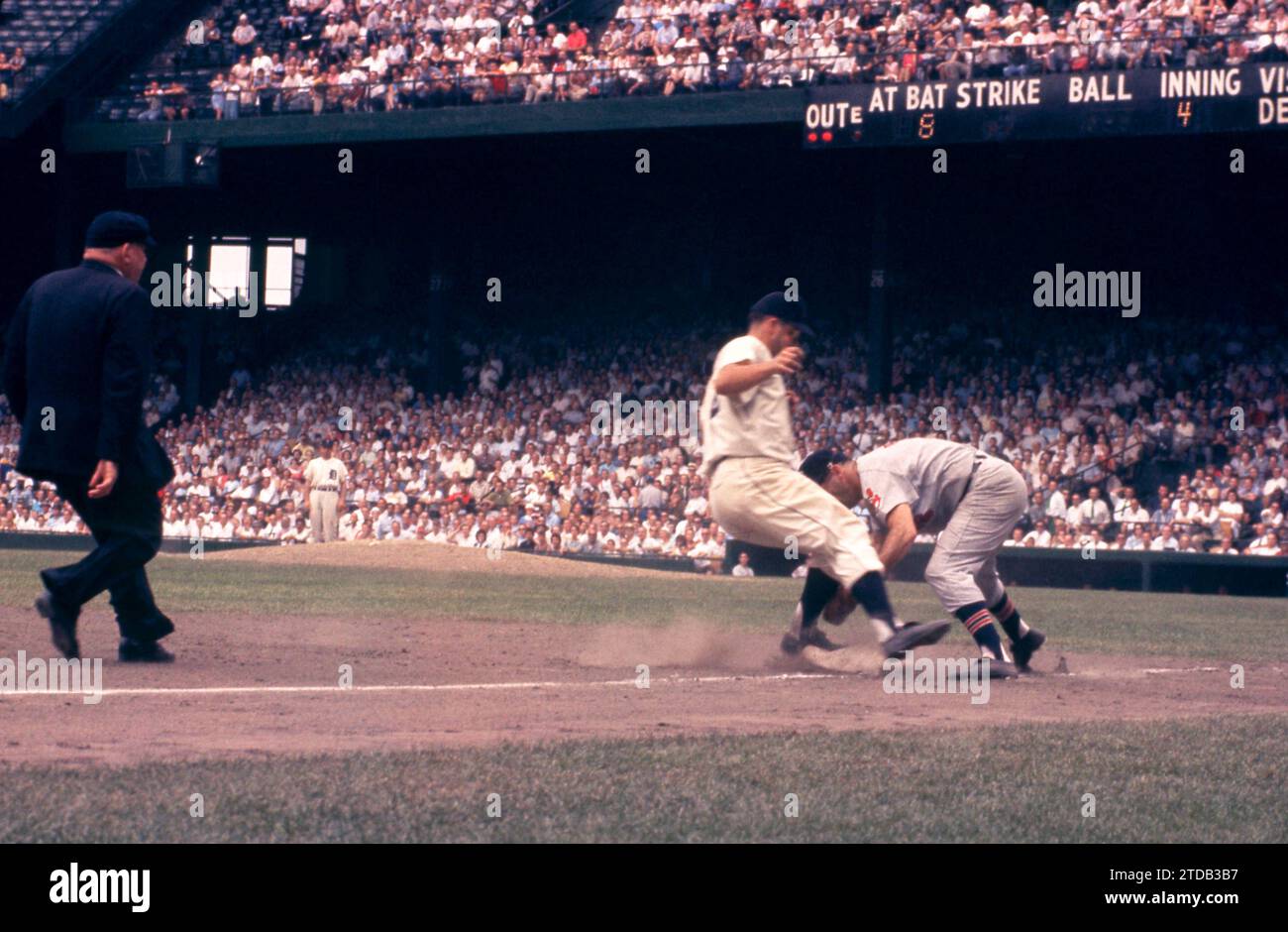 DETROIT, MI - JULY 5: Third baseman Granny Hamner #7 of the Cleveland Indians misses the tag as Bobo Osborne #32 of the Detroit Tigers reaches third base as umpire Bill Summers is there to make the call during an MLB game on July 5, 1959 at Briggs Stadium in Detroit, Michigan. (Photo by Hy Peskin) *** Local Caption *** Granny Hamner;Bobo Osborne;Bill Summers Stock Photo