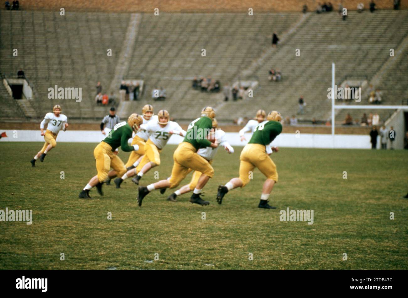 SOUTH BEND, IN - APRIL 16: The Notre Dame alumni team (white) plays against the Notre Dame varsity team (green) during an alumni game on April 16, 1957 at Notre Dame Stadium in South Bend, Indiana. (Photo by Hy Peskin) Stock Photo