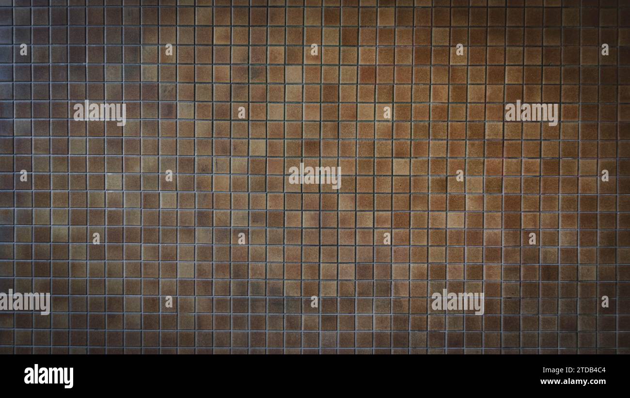 Background image displays a wall covered entirely with square brown tiles Stock Photo